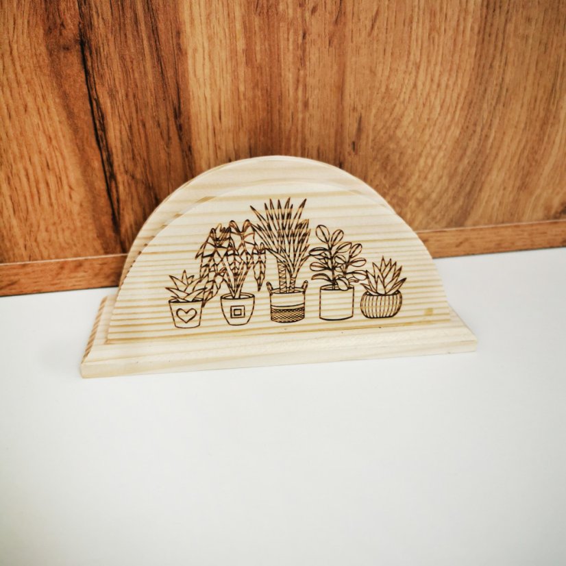 Drevený stojan na servítky s gravírovanými izbovými rastlinami.