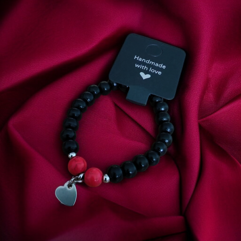Dámsky čierny náramok s medzidielmi, s visiacim srdiečkom a dvoma červenými korálkami.
