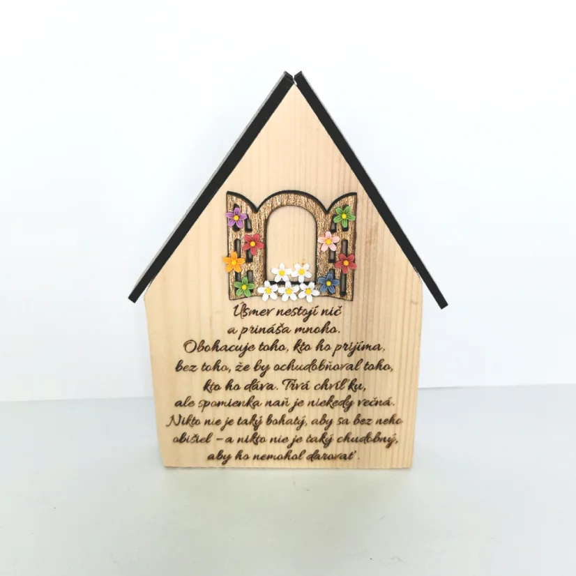 Drevený domček s gravírovaným motivačným citátom "Úsmev nestojí nič a prináša mnoho, obohacuje toho kto ho prijíma bez toho, že by ochudobňoval toho, kto ho dáva...".