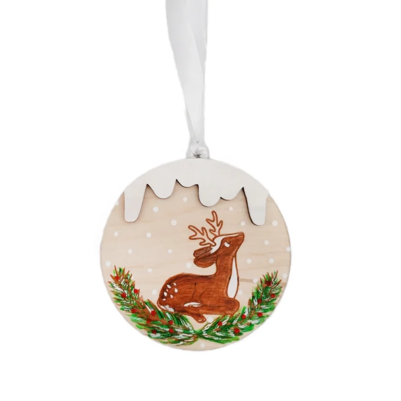 Drevená ozdoba na stromček s gravírovanou a ručne maľovanou srnkou ležiacou vo vianočnom ihličí.