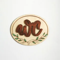 Drevená tabuľka na dvere s hnedým nápisom WC, s ručne maľovanými jemnými lístkami.