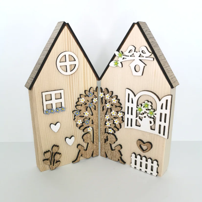 Masívne drevené domčeky zdobené výrezmi v rôznych farebných variáciách - okienka, kvety, strom, plot.