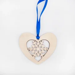 Drevená vianočná ozdoba v tvare srdca vnútri ktorého je vyrezávaná vločka, zavesené na modrej stuhe.