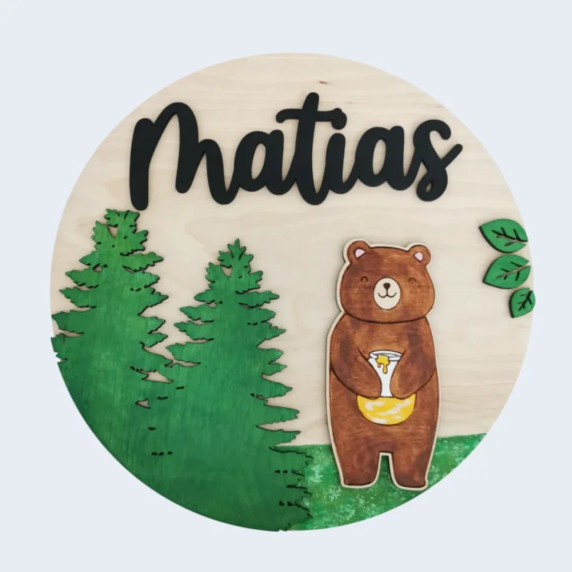 Chlapčenská okrúhla menovka s medveďom, ihličnatými stromami a menom.