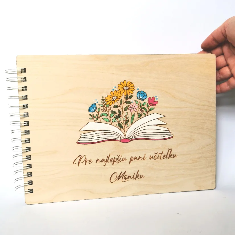 Drevený personalizovaný album s gravírovanou a ručne maľovanou knihou, z ktorej vychádzajú lúčne kvety, pod tým gravírované venovanie.