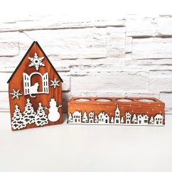 Drevený domček v hnedej lazúre s bielymi vianočnými výrezmi a k nemu zladený svietnik, ktorý je zdobený bielou zasneženou krajinkou kolom dokola.