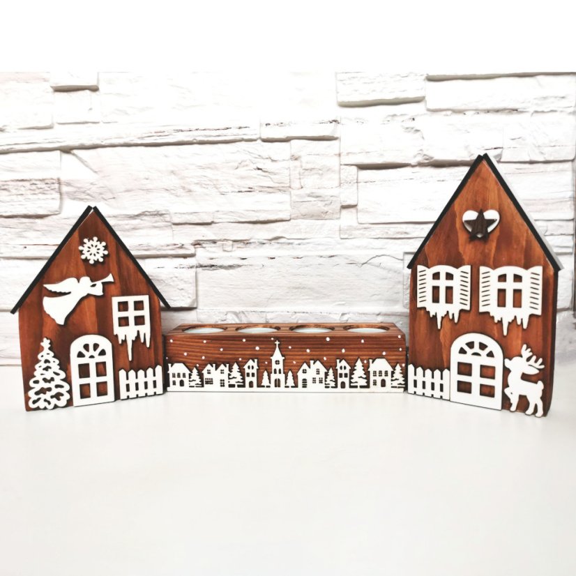 Drevené domčeky v hnedej lazúre a k nim zladený svietnik, ktorý je zdobený bielou zasneženou krajinkou kolom dokola.