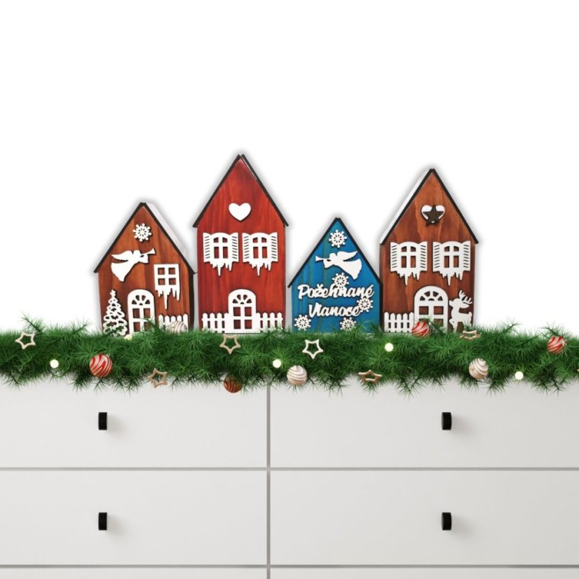 Štyri drevené domčeky naaranžované na komode, v rôznych odtieňoch lazúr, zdobené bielymi výrezmi s vianočnými a zimnými motívmi.