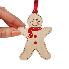 Drevená vianočná ozdoba v tvare perníčku s červeným šálom a stuhou.