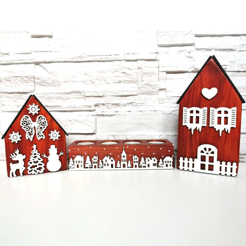 Drevené domčeky v gaštanovej lazúre a k nim zladený svietnik, ktorý je zdobený bielou zasneženou krajinkou kolom dokola.