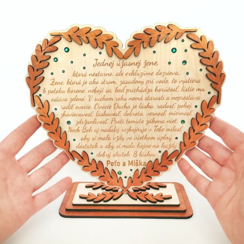 Drevené srdce v podstave, po obvode ozdobené maľovanými klasmi vo farbe podľa želania, dozdobené zelenými kamienkami a s gravírovaným vlastným textom.