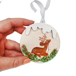 Drevená ozdoba na stromček s gravírovanou a ručne maľovanou srnkou ležiacou vo vianočnom ihličí. Drevená ozdoba na stromček s gravírovanou a ručne maľovanou srnkou ležiacou vo vianočnom ihličí.