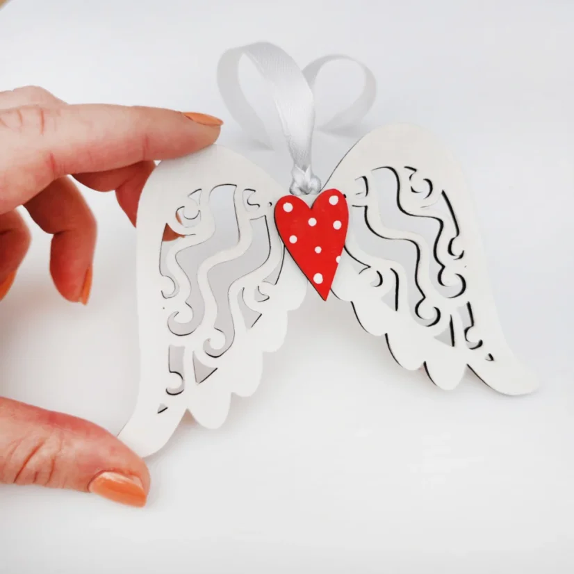 Biele drevené anjelské krídla s červeným srdiečkom.