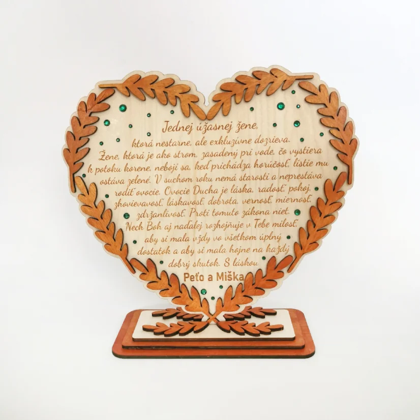 Drevené srdce v podstave, po obvode ozdobené maľovanými klasmi vo farbe podľa želania, dozdobené zelenými kamienkami a s gravírovaným vlastným textom.