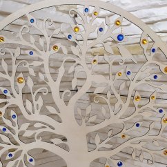 Detail dreveného stromu s kraľovsky modrými a zlato žltými kamienkami.