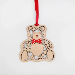 Drevená vianočná ozdoba v tvare medvedíka s červenou mašľou na krku a stuhou v rovnakej farbe. Drevená vianočná ozdoba v tvare medvedíka s červenou mašľou na krku a stuhou v rovnakej farbe.