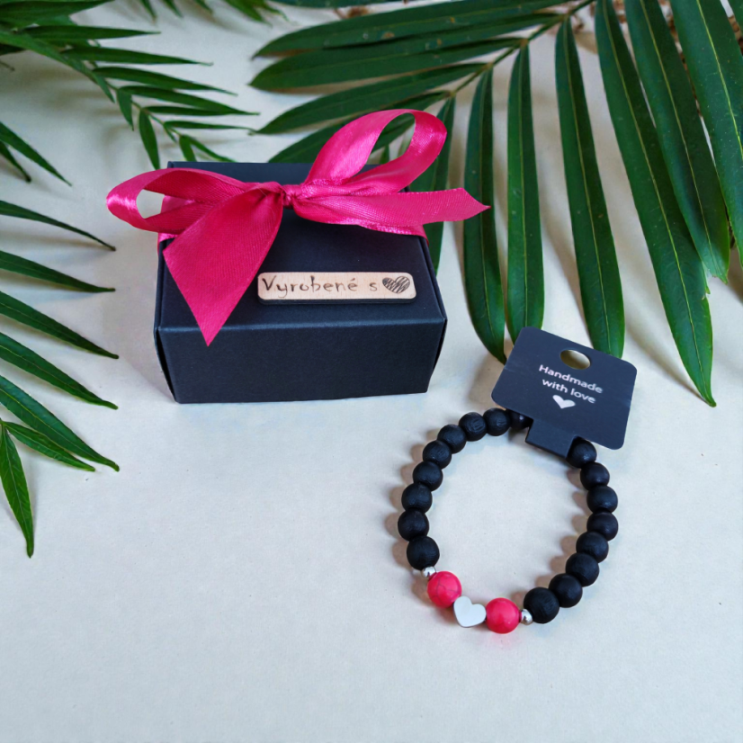 Dámsky čierny náramok so srdiečkom, medzidielmi a dvoma červenými korálkami.
