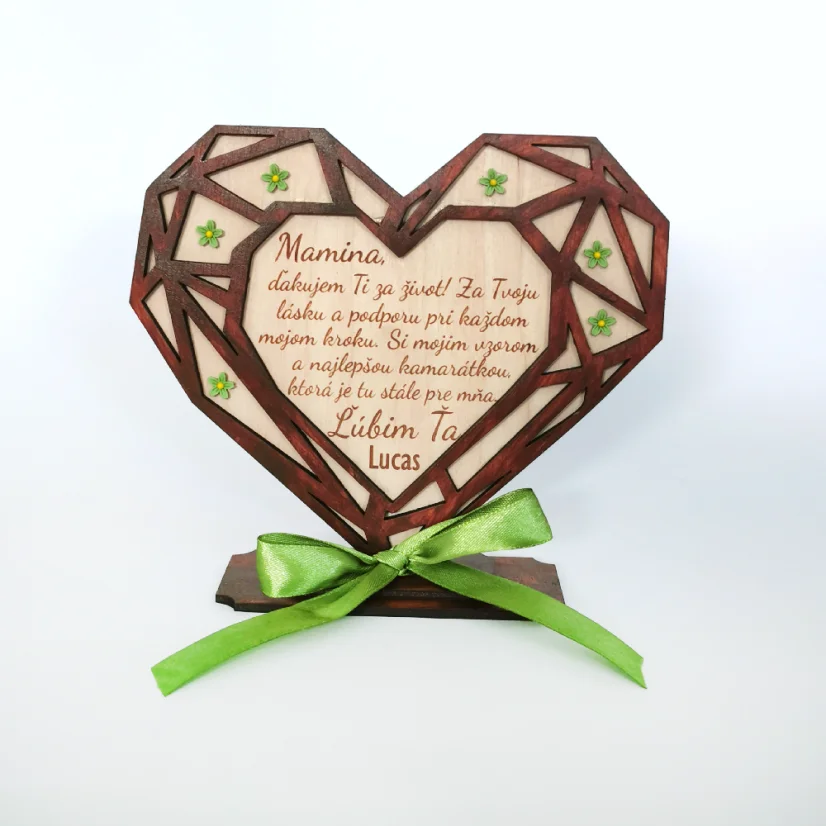 Drevené srdce v geometrickom tvare umiestnené v podstave, zdobené zelenými akrylovými kvietkami, s gravírovaným textom a venovaním. Predná strana vyrezávaná z hnedého HDF materiálu, zadná strana z prírodného dreveného materiálu.