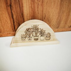 Drevený stojan na servítky s gravírovanými izbovými rastlinami.