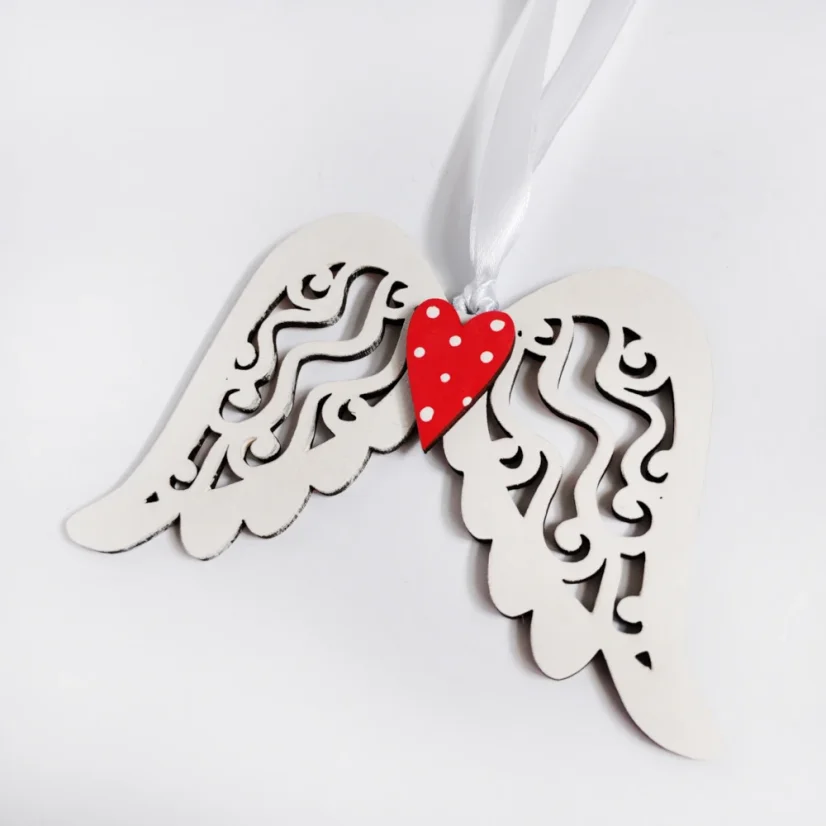 Biele drevené anjelské krídla s červeným srdiečkom.