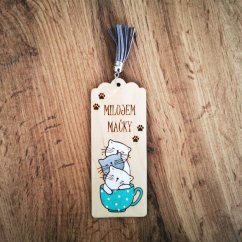 Drevená záložka s gravírovanými a maľovanými mačiatkami v hrnčeku, s textom "Milujem mačky" a sivým strapcom.