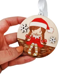 Drevená ozdoba na stromček s gravírovaným a ručne maľovaným dievčatkom v červenej mikulášskej čapiciu. Drevená ozdoba na stromček s gravírovaným a ručne maľovaným dievčatkom v červenej mikulášskej čapiciu.