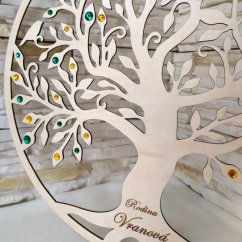 Detail dreveného stromu so smaragdovo zelenými a zlato žltými kamienkami.