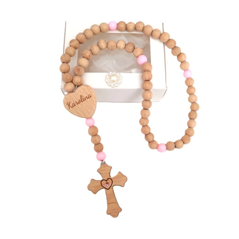 Ruženec s menom z bukových korálkov a krížiku, ružové desiatky z akrylu, v strede krížiku vložený kamienok vo farbe desiatkov. Ruženec položený na bielej darčekovej krabičke.