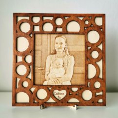 Gravírovaná fotka na dreve s ručne maľovaným hnedým orámovaním v tvare kruhov, v dolnej časti výrez srdca s vlastným gravírovaným dvojslovným textom, v drevenom stojane.