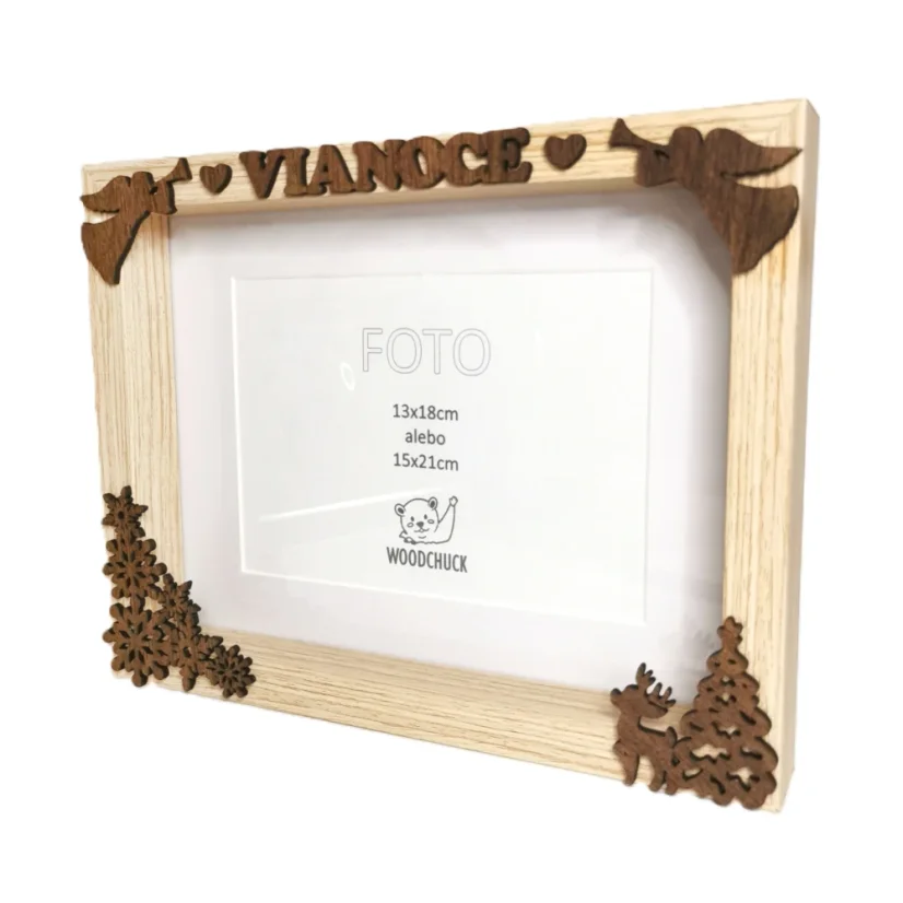 Rámik z bledého dreva s pripevnenými hnedými vianočnými výrezmi - vločky, anjeli, nápis Vianoce, srnček.