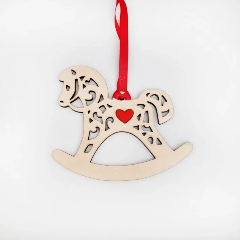 Drevená vianočná ozdoba v tvare húpacieho koníka s červeným srdiečkom v strede a stuhou v rovnakej farbe.
