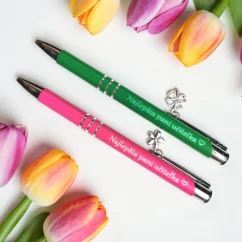 Kovové ružové pero s príveskom kvietok a kovové zelené pero s príveskom štvorlístok, gravírovaný text "Najlepšia pani učiteľka".