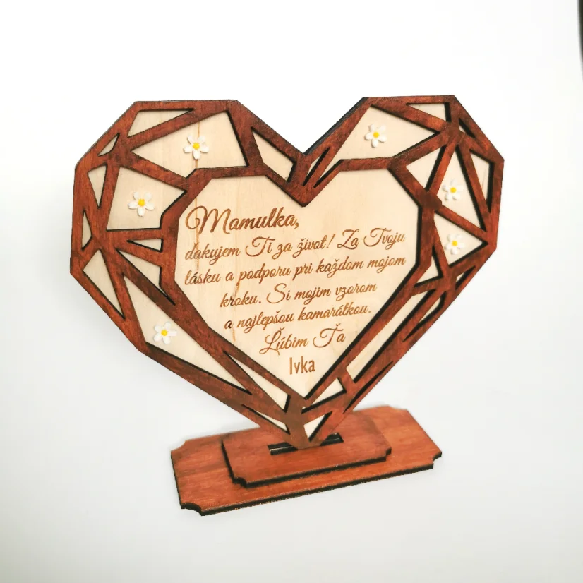 Drevené srdce v geometrickom tvare umiestnené v podstave, zdobené bielymi akrylovými kvietkami, s gravírovaným textom a venovaním. Predná strana vyrezávaná z hnedého HDF materiálu, zadná strana z prírodného dreveného materiálu.