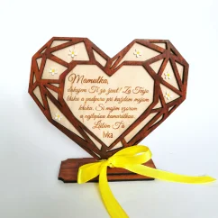 Drevené srdce v geometrickom tvare umiestnené v podstave, zdobené bielymi akrylovými kvietkami, s gravírovaným textom a venovaním. Predná strana vyrezávaná z hnedého HDF materiálu, zadná strana z prírodného dreveného materiálu.