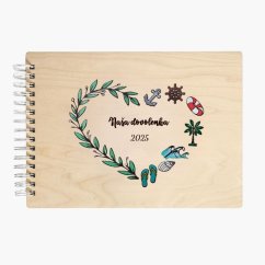 evený album s nápisom "Naša dovolenka 2025", s gravírovanými a ručne maľovanými lístkami a motívmi dovolenky - kotva, kormidlo, koleso, palma, vlny, mušľa, plážová obuv - všetko usporiadané do tvaru srdca.