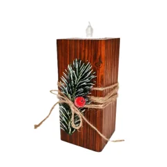 Drevený vianočný svietnik v hnedej lazúre, s kúskom zasneženého ihličia a červenou bobuľkou, obmotaný jutovým špagátom.