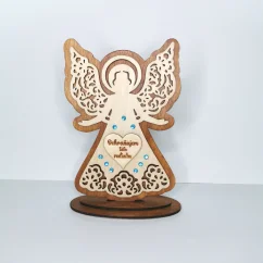 Drevený anjel v podstave zdobený modrými kamienkami, v srdci gravírovaný text "Ochraňujem túto rodinku".