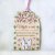 Drevená tabuľka s textom "Vitajte u nás, upratané sme mali včera, škoda že ste to nestihli", so siluetami postáv a s ručne maľovanými kvietkami a lístkami. 
