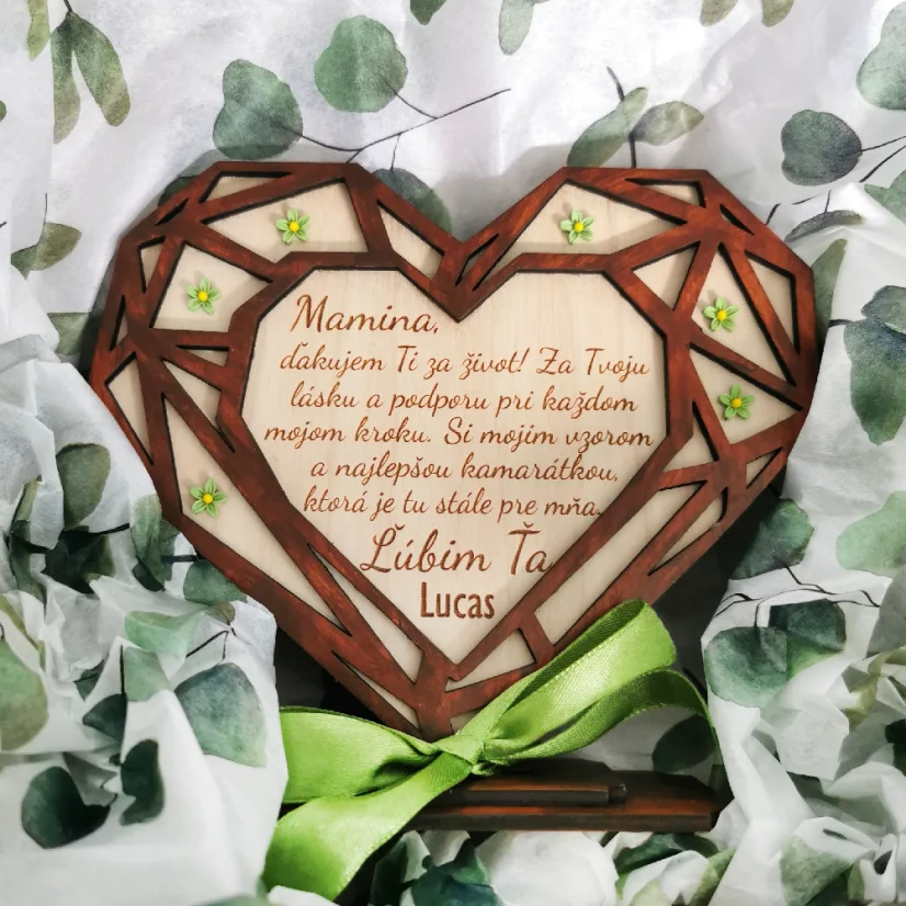 Drevené srdce v geometrickom tvare umiestnené v podstave, zdobené zelenými akrylovými kvietkami, s gravírovaným textom a venovaním. Predná strana vyrezávaná z hnedého HDF materiálu, zadná strana z prírodného dreveného materiálu.