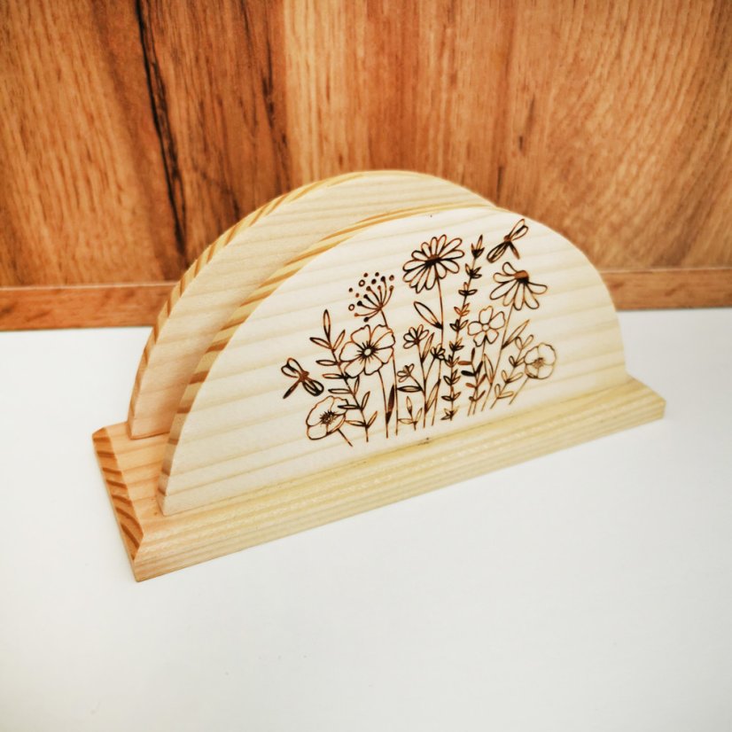 Drevený stojan na servítky s gravírovanými lúčnymi kvetmi.