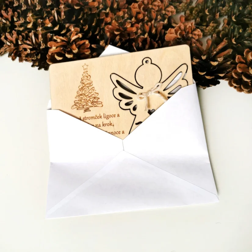 Vianočná pohľadnica s vlastným gravírovaným textom a venovaním, s vyberateľnou ozdobou anjela a s bielou obálkou.