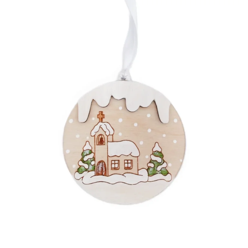 Drevená ozdoba na stromček s gravírovaným a ručne maľovaným zasneženým kostolíkom a ihličnatými stromami.