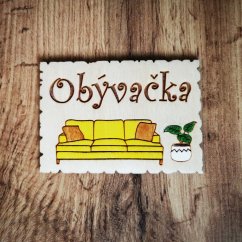 Drevená tabuľka na dvere s nápisom "Obývačka", s gravírovaným a ručne maľovaným gaučom a izbovou rastlinou.
