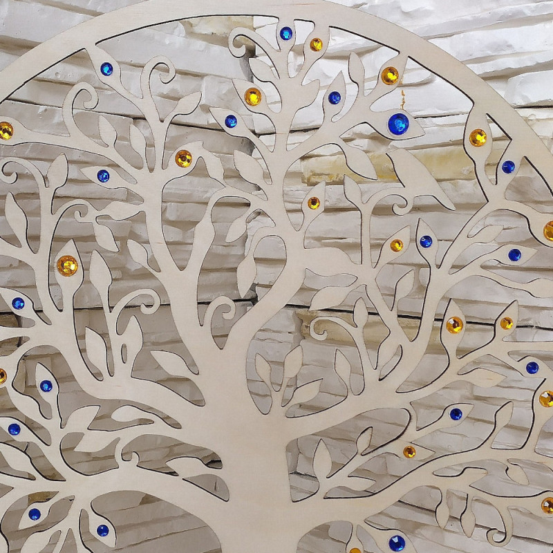 Detail dreveného stromu s kraľovsky modrými a zlato žltými kamienkami.