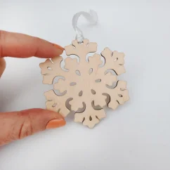 Drevená vianočná ozdoba snehová vločka so stuhou.