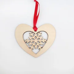 Drevená vianočná ozdoba v tvare srdca vnútri ktorého je vyrezávaná vločka, zavesené na červenej stuhe.